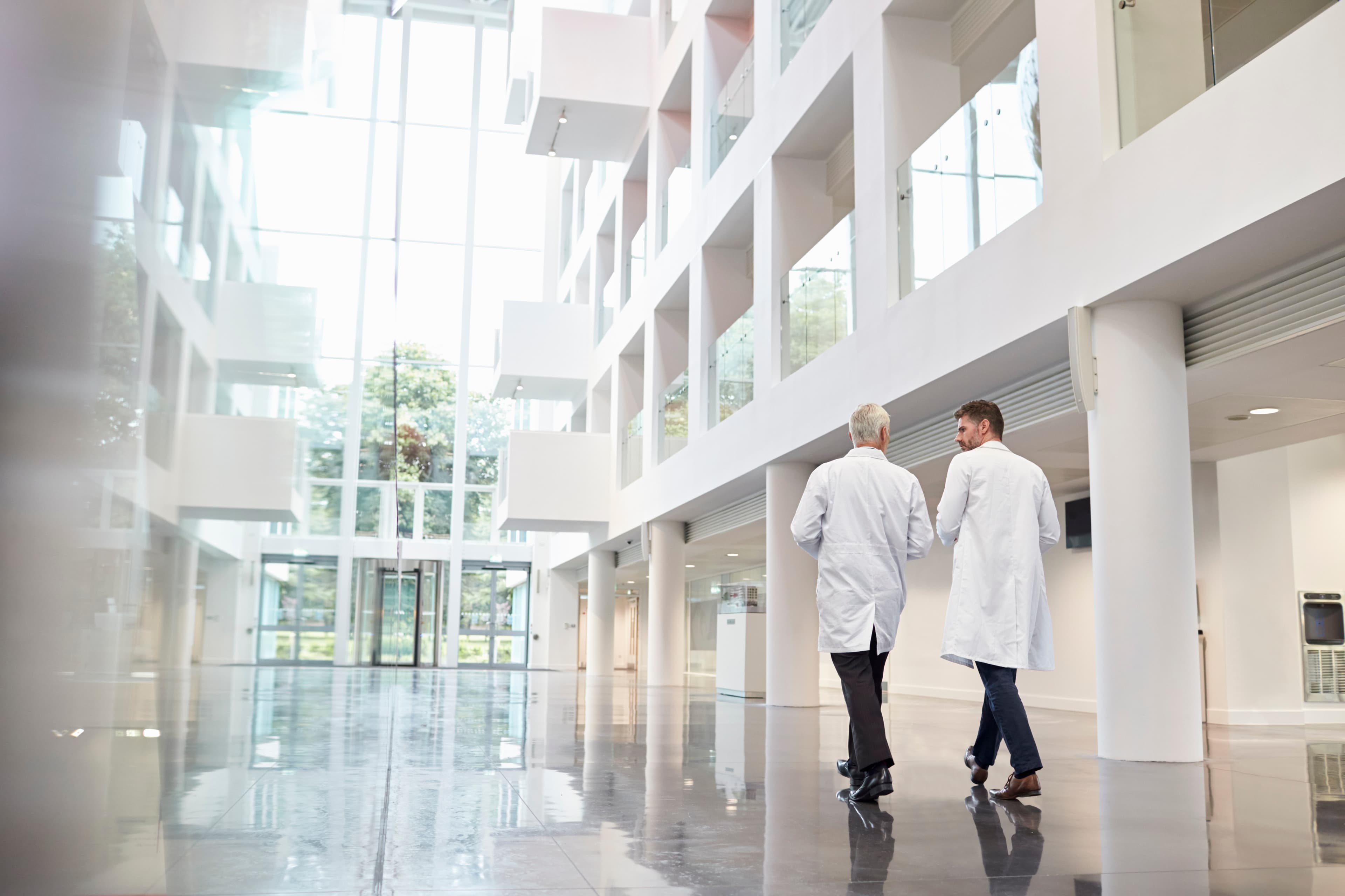 Healthcare professionals walking through hospital atrium
